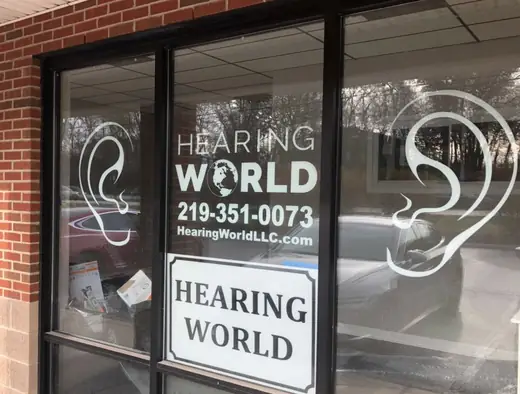 Storefront glass with white window lettering and a logo graphic